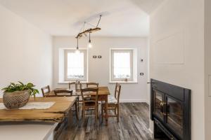 una cucina e una sala da pranzo con tavolo e sedie in legno di Casa21 a SantʼAntonio Tortal
