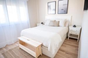 um quarto branco com uma cama branca e uma mesa em SAMIL PLAYA SUR em Vigo