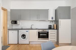 een keuken met witte kasten en een wasmachine en droger bij Vista Rio - apartamento in Portimão