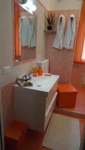 y baño con lavabo, espejo y toallas. en Terrazza Sul Mare en Terme Vigliatore