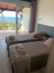 twee bedden in een slaapkamer met uitzicht op de oceaan bij Duplex Rose Porcelaine - Vue Mer- Malendure in Bouillante