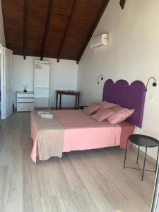 a bedroom with a pink bed and a table at Duplex Rose Porcelaine - Vue Mer- Malendure in Bouillante