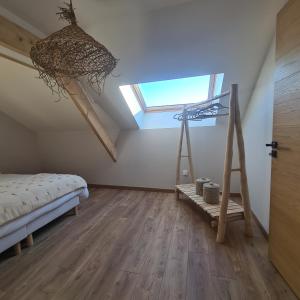 ein Schlafzimmer mit einem Bett und einem Dachfenster in der Unterkunft Ô Nuit Claire, superbe longère avec spa. in Dompierre-sur-Helpe