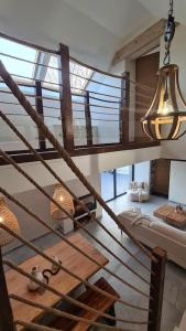 - un escalier en colimaçon dans un bâtiment doté d'un lustre dans l'établissement Ô Nuit Claire, superbe longère avec spa., à Dompierre-sur-Helpe