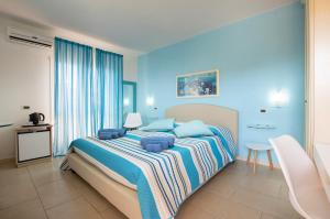 1 dormitorio con 1 cama grande y paredes azules en LeCalleBed-Breakfast en Chia