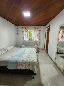 a bedroom with a bed and a window and a mirror at Sítio Donana Sana in Macaé