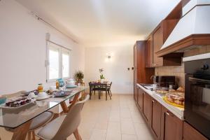 una cocina grande con mesa y sillas. en LeCalleBed-Breakfast en Chia