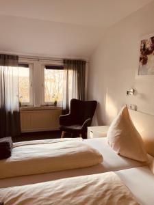 a hotel room with a bed and a chair at Zum Deutschen Heinrich in Gifhorn