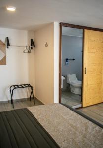 Cette chambre comprend un lit et une salle de bains pourvue de toilettes. dans l'établissement Hotel Ciclovía & Terraza, à Zitácuaro