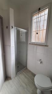 ein weißes Bad mit einem WC und einer Dusche in der Unterkunft casa vacanza fronte mare Fano Sassonia 2 in Fano