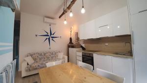 una cucina con tavolo e divano in una camera di casa vacanza fronte mare Fano Sassonia 2 a Fano