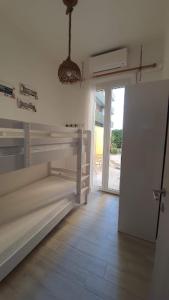 a bedroom with bunk beds and a door to a patio at casa vacanza fronte mare Fano Sassonia 2 in Fano