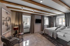 a bedroom with a bed and a chair and windows at Sea Rocks Residence in Dubrovnik