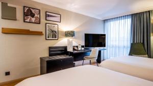a hotel room with two beds and a desk at Holiday Inn Hotel Brussels Airport by IHG in Diegem +60 photos