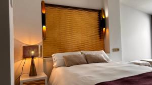 a bedroom with a white bed and a window at HOTEL FUENTE REDONDA LUXURY in Úbeda