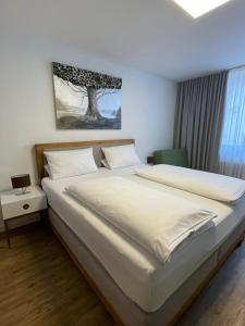Un dormitorio con una gran cama blanca y una ventana en Altstadt Hotel Self Check-In, en Würzburg
