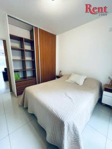 Un dormitorio con una cama con una manta blanca. en Rent Nicasio Oroño en Buenos Aires