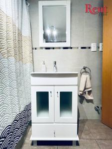 y baño con lavabo blanco y espejo. en Rent Nicasio Oroño en Buenos Aires
