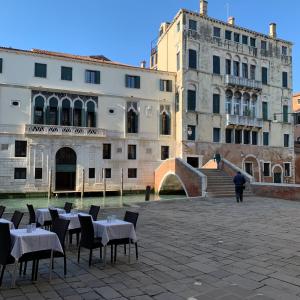 een groep tafels en stoelen voor een gebouw bij Charme Holidays Venice in Venetië