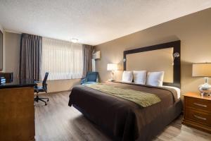 Pokój hotelowy z łóżkiem i biurkiem w obiekcie Rodeway Inn & Suites Hwy 217 & 26 W w mieście Portland