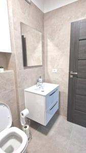 a bathroom with a toilet and a sink and a mirror at Apartament Adora Alex in Arad