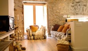 uma sala de estar com dois sofás e uma televisão em Clauhomes Casa Rural Deluxe em Tarrés