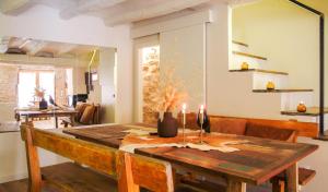 uma sala de jantar com uma mesa de madeira com velas em Clauhomes Casa Rural Deluxe em Tarrés
