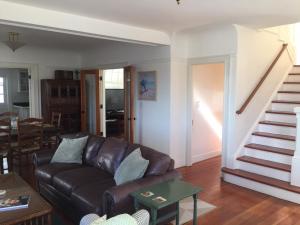 sala de estar con sofá de cuero marrón y escaleras en 3118 Yellow House Main home, en Pacific Grove