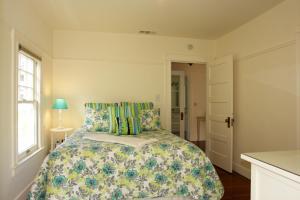 1 dormitorio con 1 cama con colcha de flores en 3118 Yellow House Main home en Pacific Grove