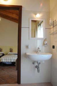 a bathroom with a sink and a mirror and a bed at Agriturismo La Fattoria Del Boschetto in Fontanellato