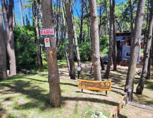 a bench in a park with a sign on a tree at Sueños de Mar in Mar Azul +17 photos