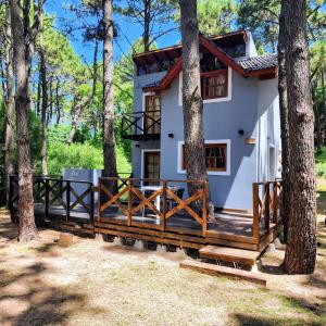 a house with a deck in the woods at Sueños de Mar in Mar Azul