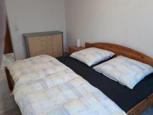 um quarto com 2 camas e uma cómoda em Fewo-Heikenberg-mit-Schwimmbad em Bad Lauterberg