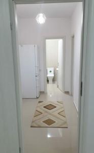 een witte badkamer met een toilet en een hal bij Two Bedroom Apartment in Roşu