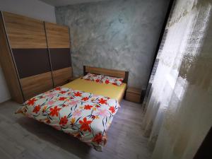 een kleine slaapkamer met een bed met bloemen erop bij Two Bedroom Apartment in Roşu