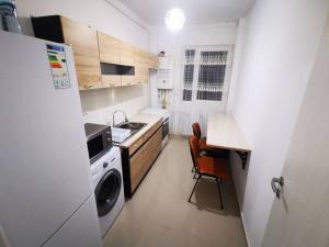 een kleine keuken met een fornuis, een wasmachine en een droger bij Two Bedroom Apartment in Roşu