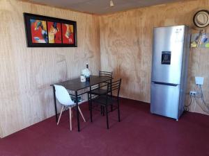 a dining room with a table and a refrigerator at Casa en parcela in Puerto Varas