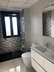 a bathroom with a toilet and a sink and a shower at Villamar in San Pedro del Pinatar