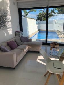 a living room with a couch and a chair and a pool at Villamar in San Pedro del Pinatar