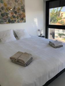 ein weißes Bett mit zwei Handtüchern darüber in der Unterkunft Villamar in San Pedro del Pinatar
