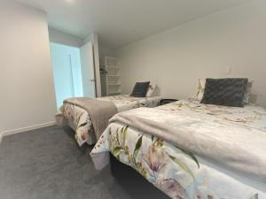2 camas en una habitación con ventana en The Lakes - Kai Iwi Lakes Exclusive Retreat en Kaihu