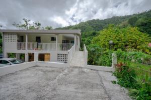 ein weißes Haus mit einem Zaun und einer Einfahrt in der Unterkunft Charmant logement F3 au sud de la Martinique (PMR) in Rivière-Pilote
