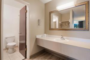 a bathroom with a sink and a toilet and a mirror at Rodeway Inn & Suites Hwy 217 & 26 W in Portland