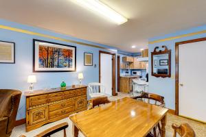 Boothbay的住宿－Blue Lagoon Escape Unit-A，一间带木桌的客厅和一间厨房