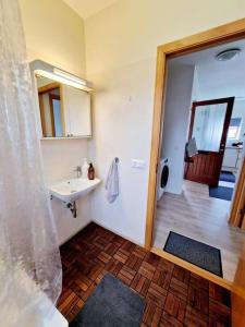 uma casa de banho com um lavatório e um chuveiro com um espelho. em Wonderful apartment with beautiful natural pearls. em Bifrost