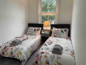亞芬河畔史特拉福的住宿－May cottage in Stratford Upon Avon，卧室内两张并排的床