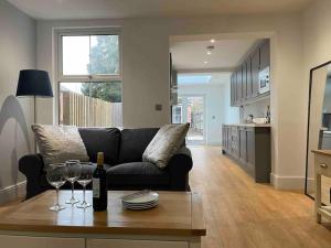 a living room with a couch and a table with wine glasses at May cottage in Stratford Upon Avon in Stratford-upon-Avon