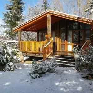Cabaña de madera con porche en la nieve en Apartamentos Turísticos Matagacha, en Villaviciosa
