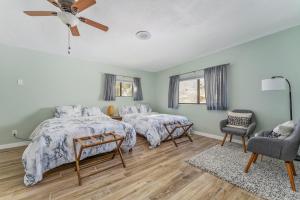 a bedroom with two beds and a chair at Close to JT Park & Town w/360 View The Green Adobe in Joshua Tree