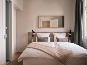 Un dormitorio con una cama grande y un espejo encima. en the breeze en Ahlbeck